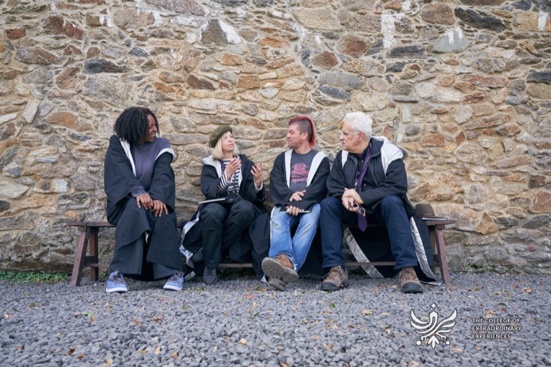 Participants talking beside a stone wall